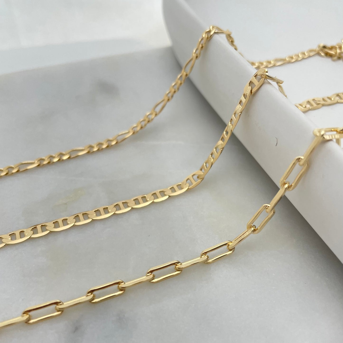 3 styles of anklet bracelets in 18k gold filled, featuring figaro chain anklet, flat mariner anklet and paperclip anklet bracelet.