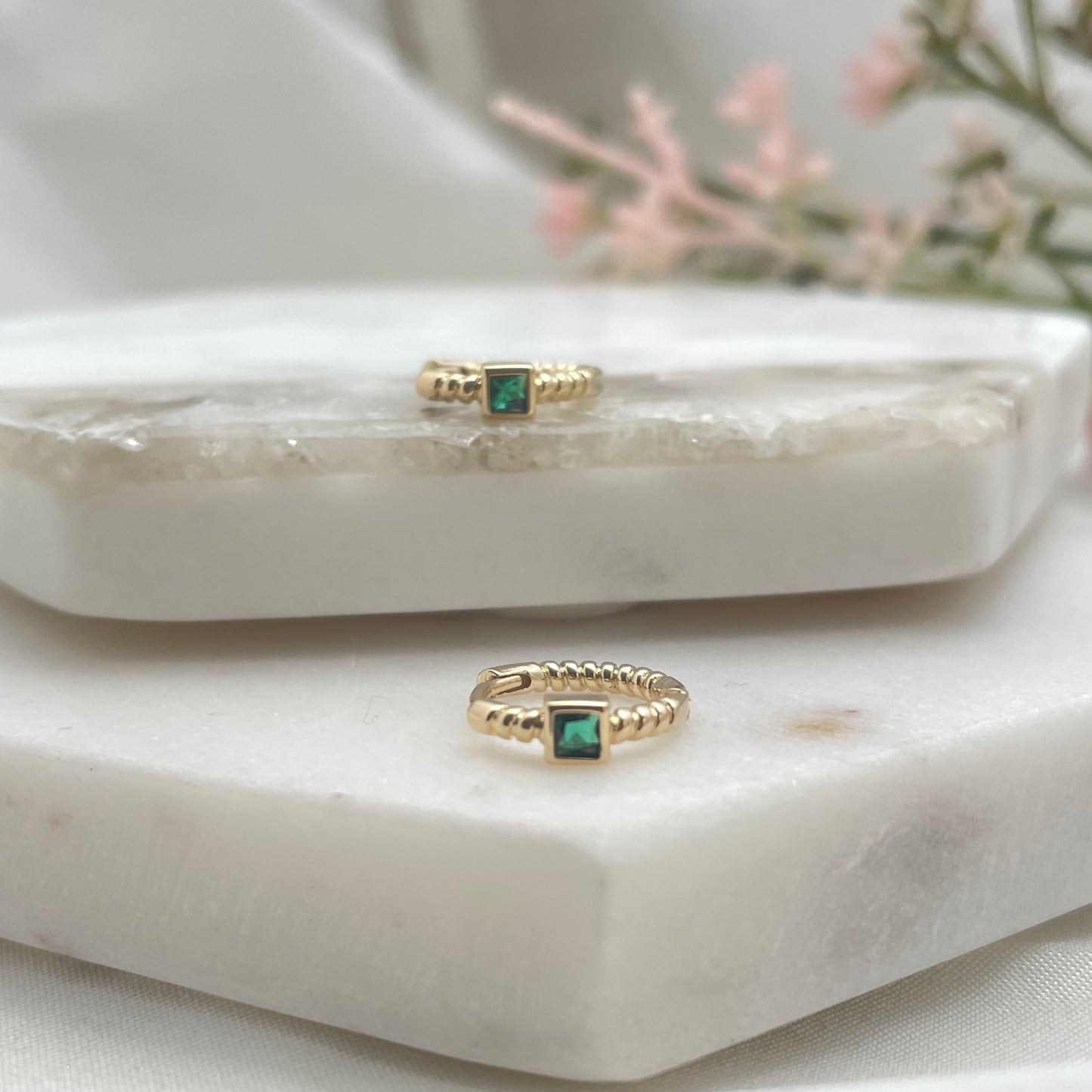 Huggie hoop with emerald like crystal in the middle