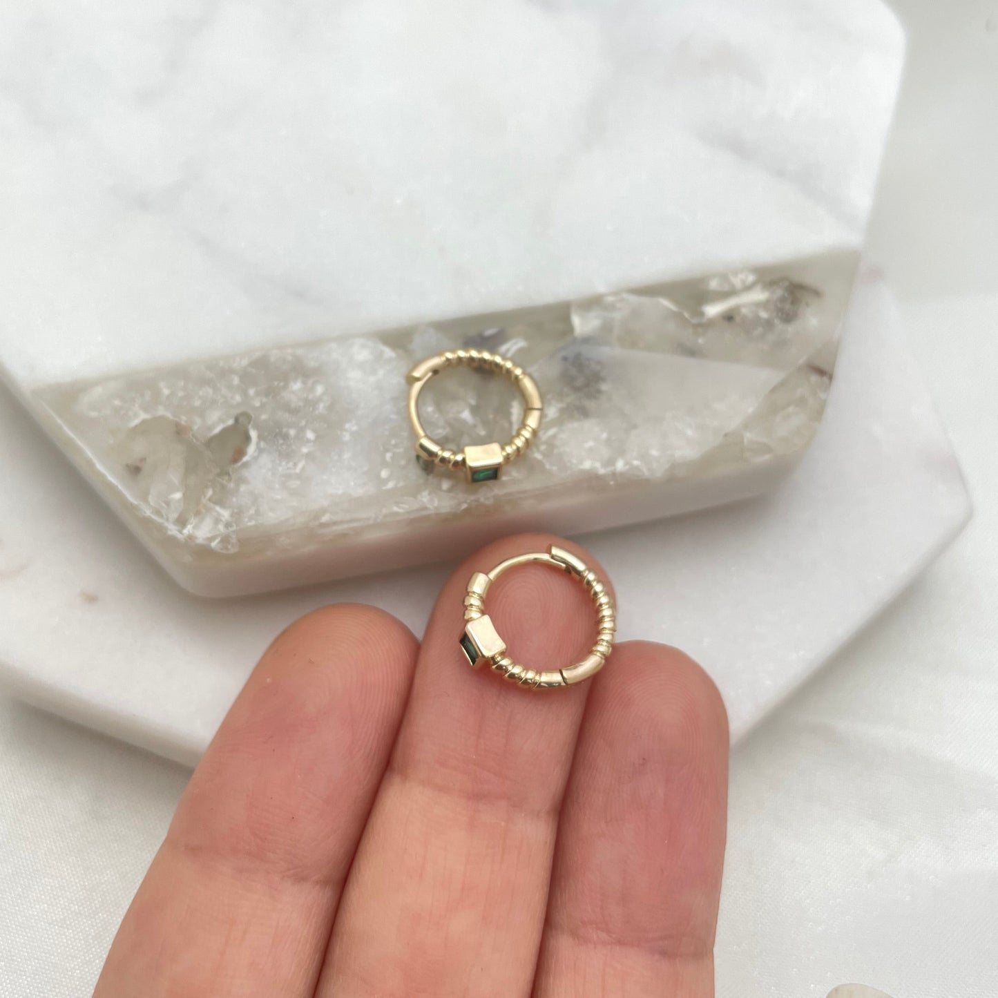 Small gold filled hoop earring on hand to appreciate size of it