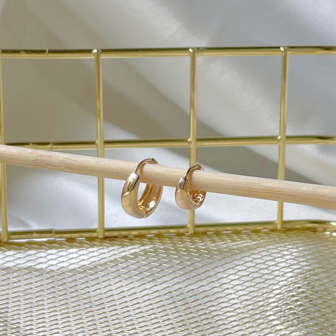 detail of water resistant huggie hoop earrings