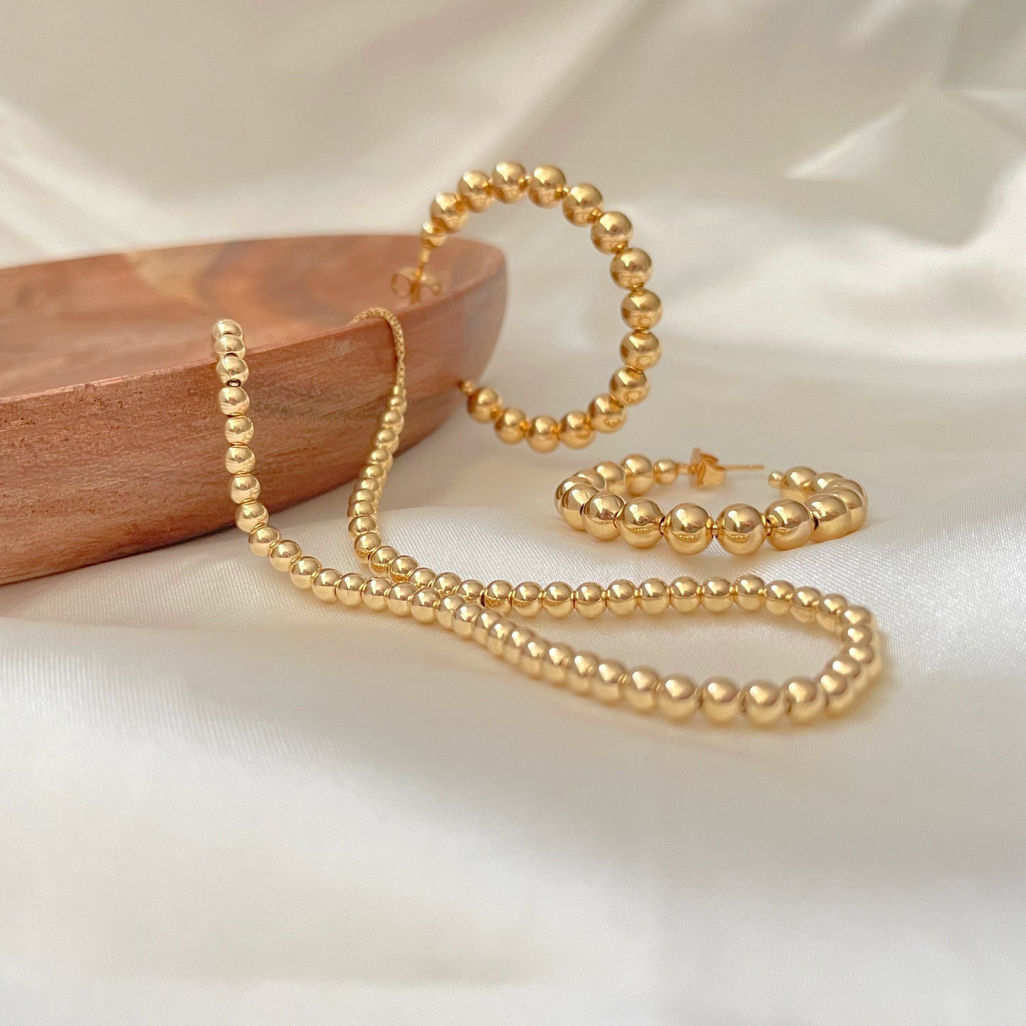 6 mm beaded hoop earrings in 18k gold filled displayed with 4 mm necklace also in 18k gold filled