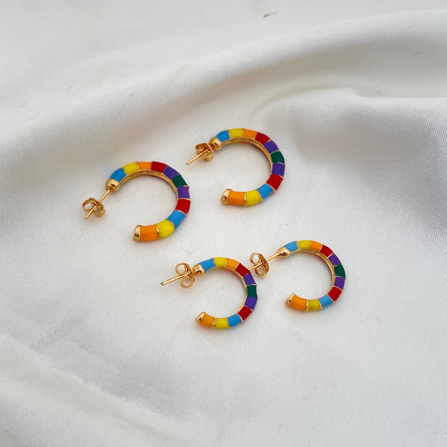 Colorful enamel hoop earrings made of 18k gold filled. Comes in small and medium size. White silk background