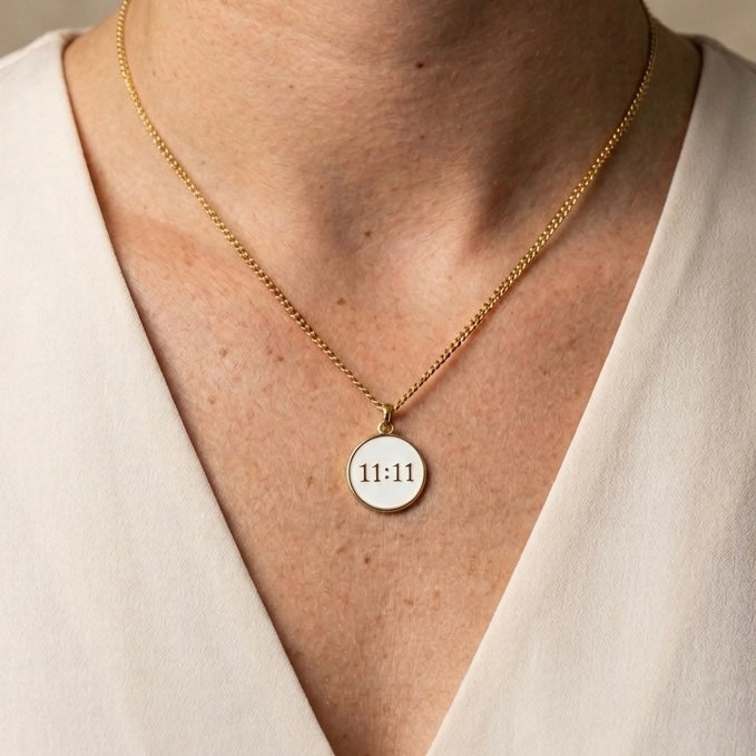 Woman wearing white enamel 11 11 necklace in gold 