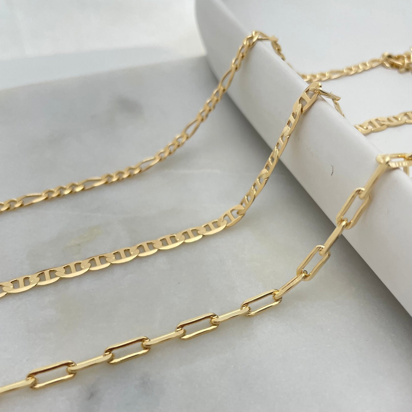 3 styles of anklet bracelets in 18k gold filled, featuring figaro chain anklet, flat mariner anklet and paperclip anklet bracelet. 