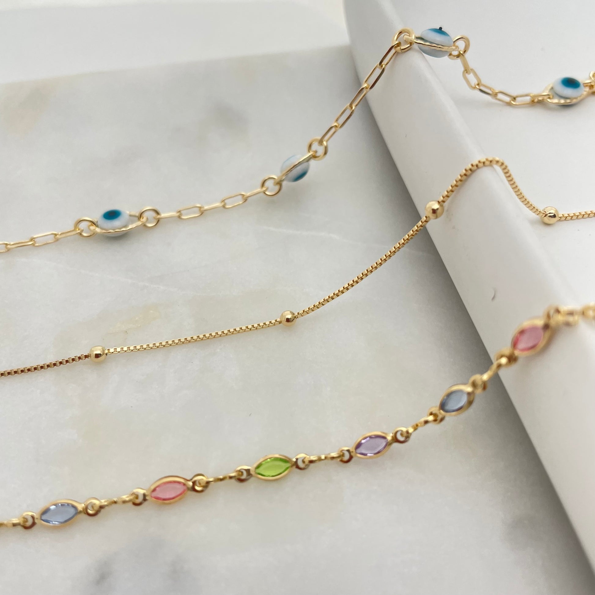 3 styles of anklet bracelets in 18k gold filled, featuring evil eye anklet, satellite anklet and colorful anklet bracelet. 