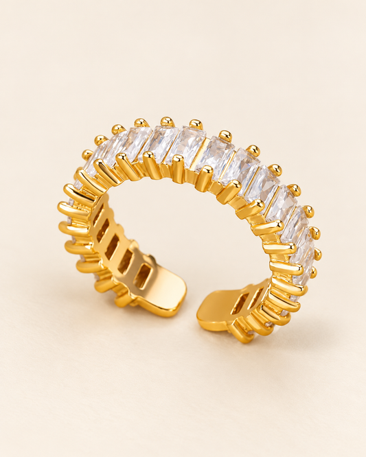 Gold plated baguette ring adjustable over cream background