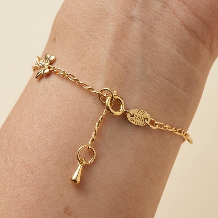 Gold filled bracelet close up to clasp  on a wrist against a beige background