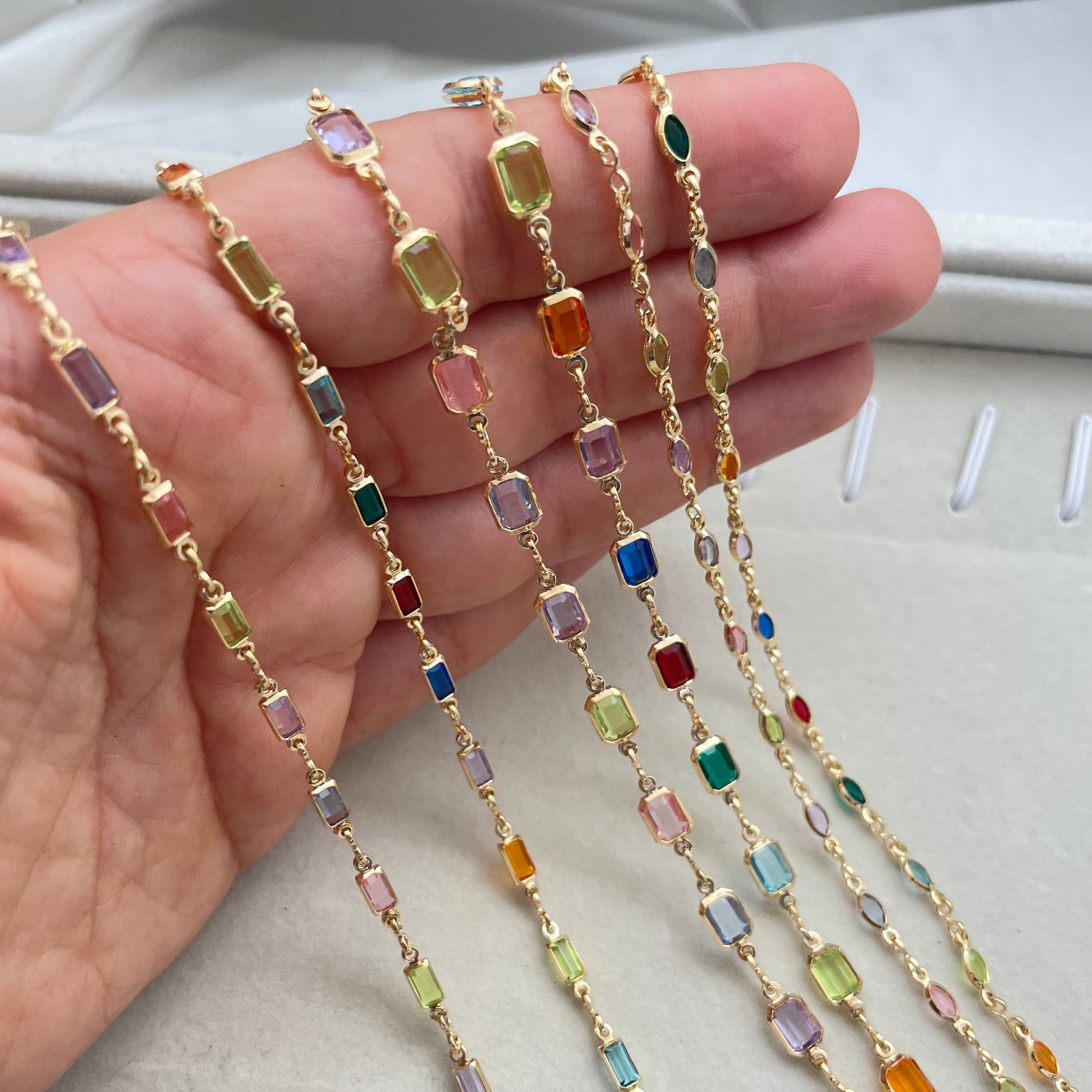 A multicolor gold-filled necklace with various colored crystals on a chain.