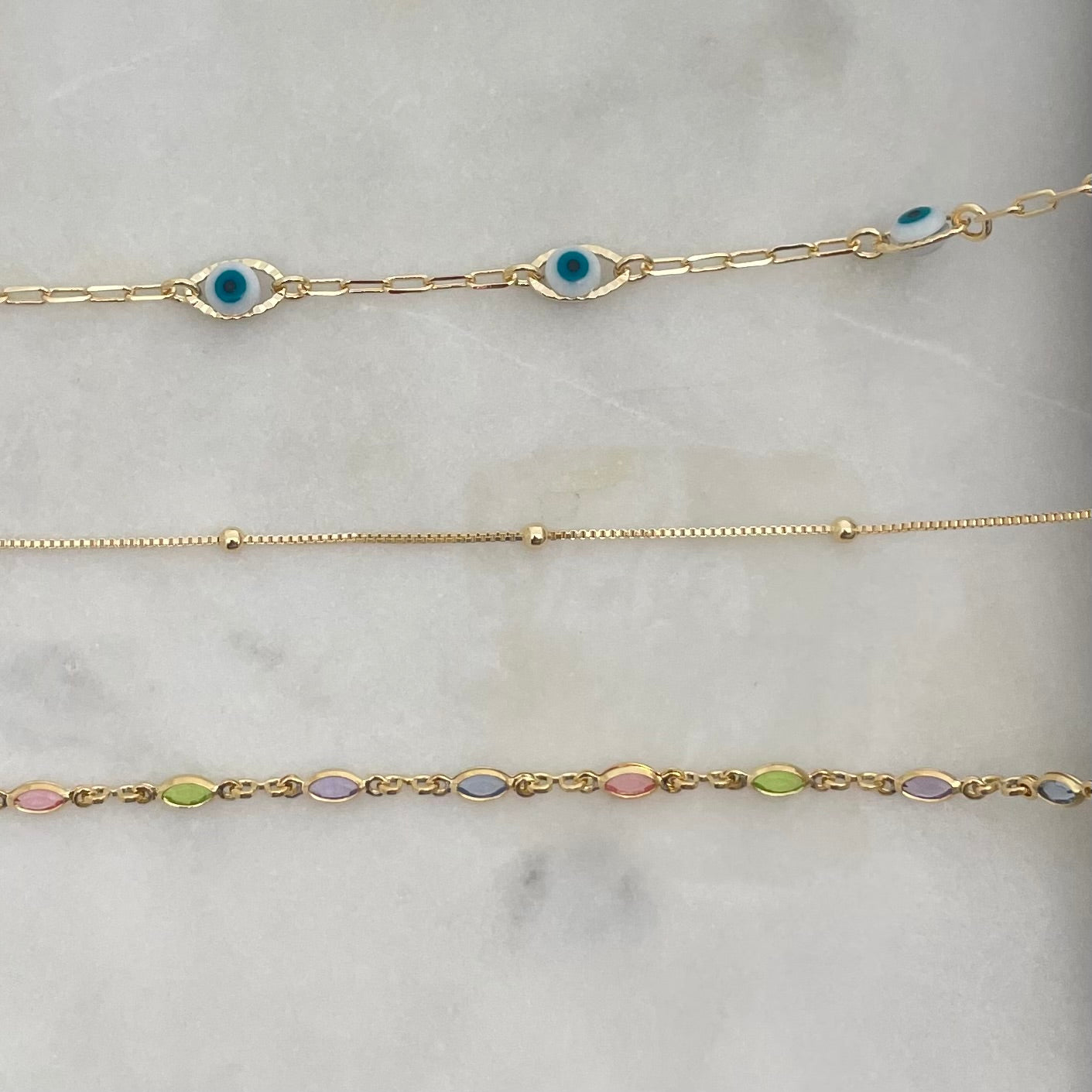 3 styles of anklet bracelets in 18k gold filled, featuring evil eye anklet, satellite anklet and colorful anklet bracelet. 