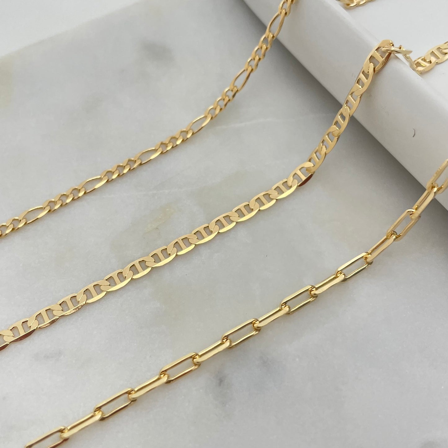 3 styles of anklet bracelets in 18k gold filled, featuring figaro chain anklet, flat mariner anklet and paperclip anklet bracelet. 