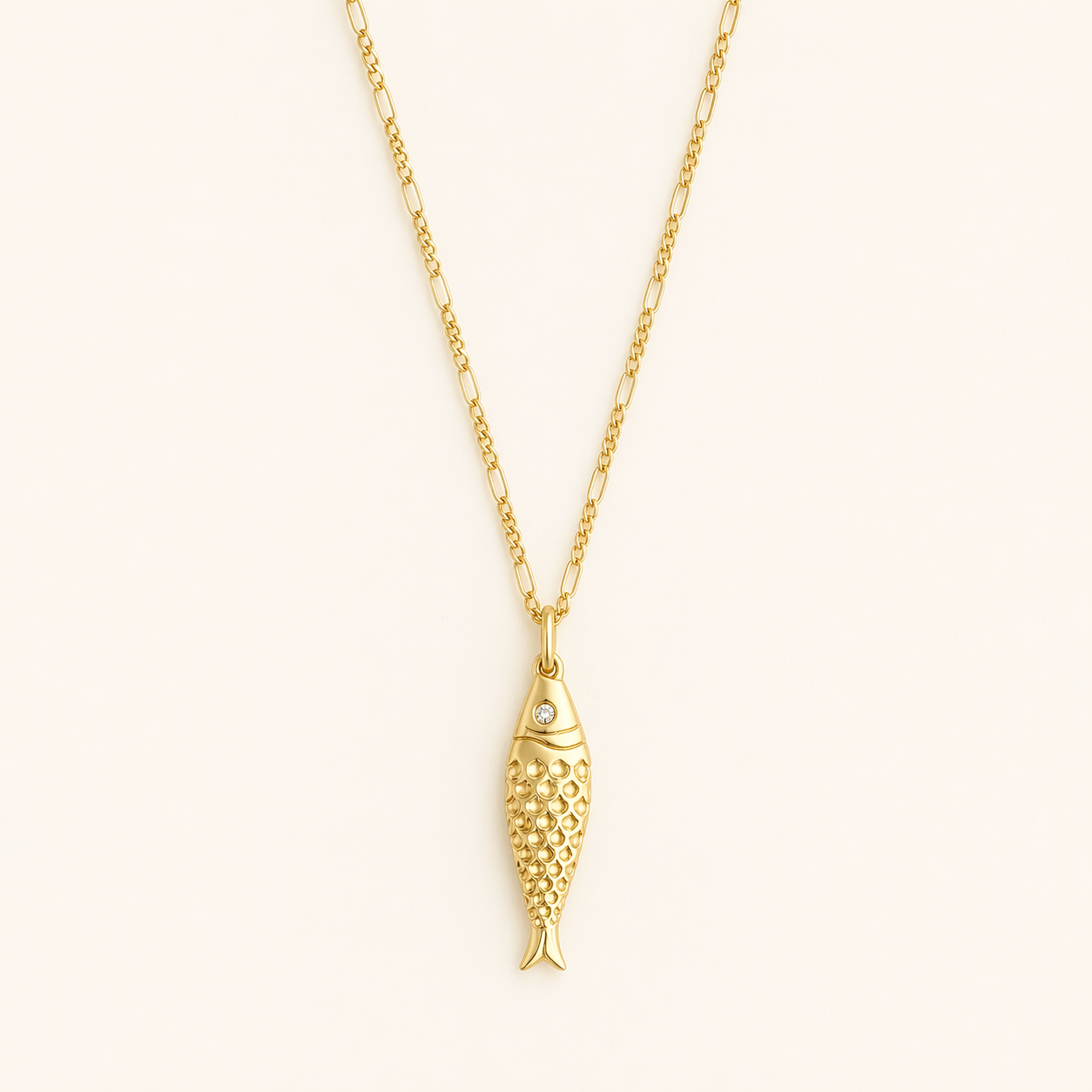 Gold fish-shaped pendant on a chain against a white background