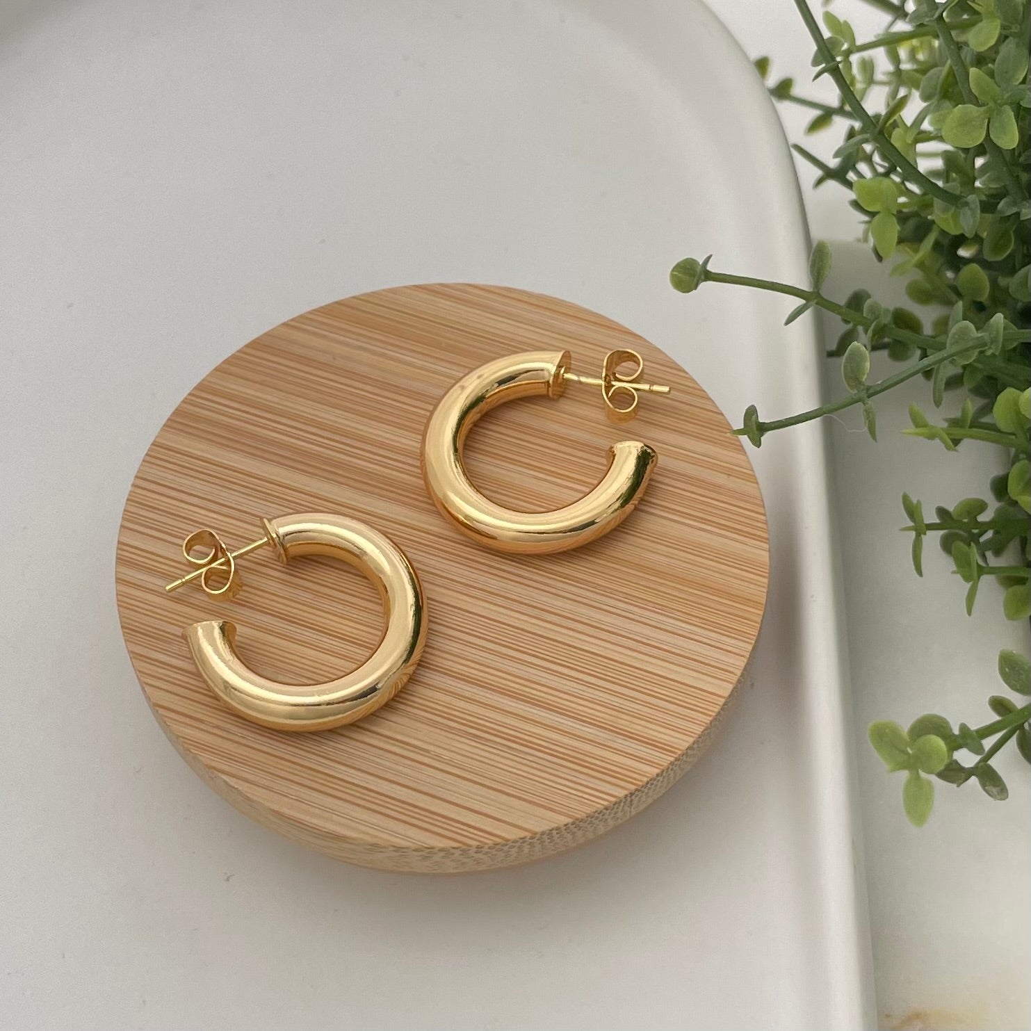 Classic Chunky Hoop Earring in 18k gold filled over wooden tray. 