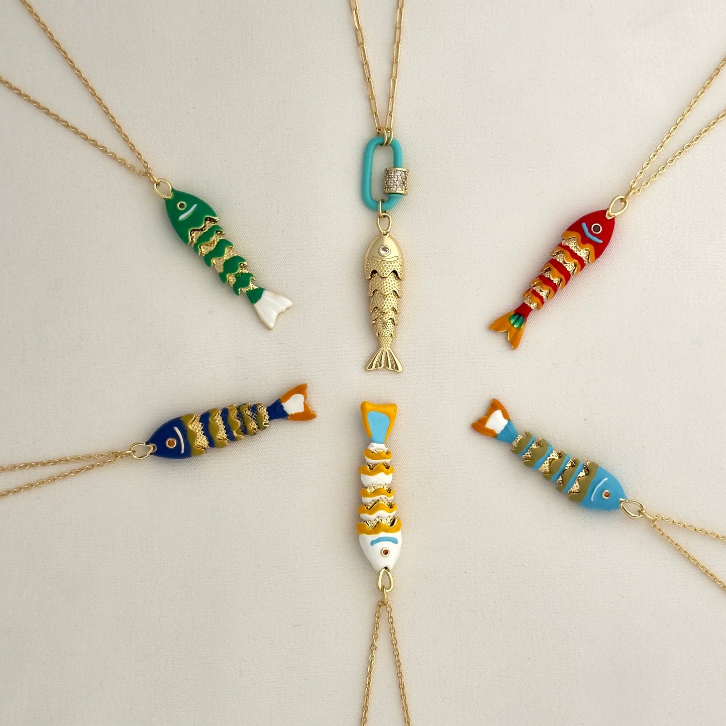 Multicolor array of fish includes Gold with turquoise clasp, red, light blue, white, dark blue and green fish.