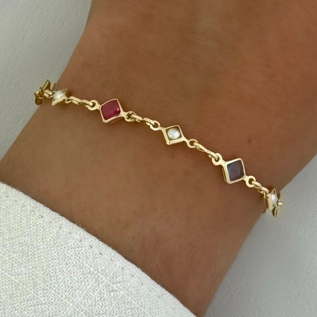 Multicolor pearl and crystal bracelet with gold filled details on woman's wrist.