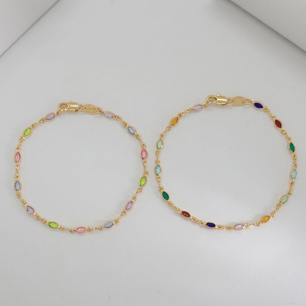 Two gold chain bracelets with small colorful marquise-cut stones, displayed on a light gray background.
