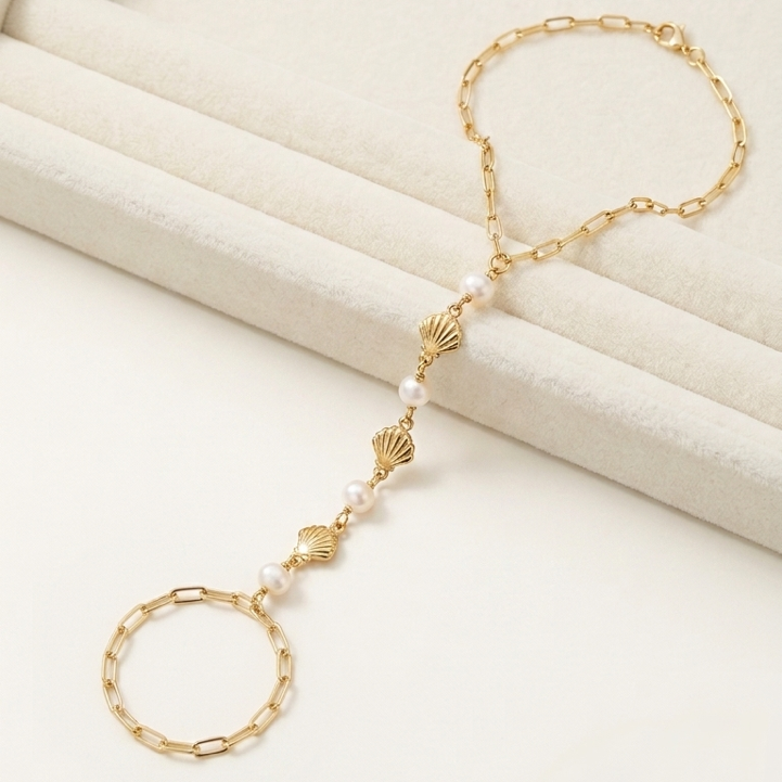 Gold filled hand chain  with  freshwater pearls and gold filled shells  on a white background