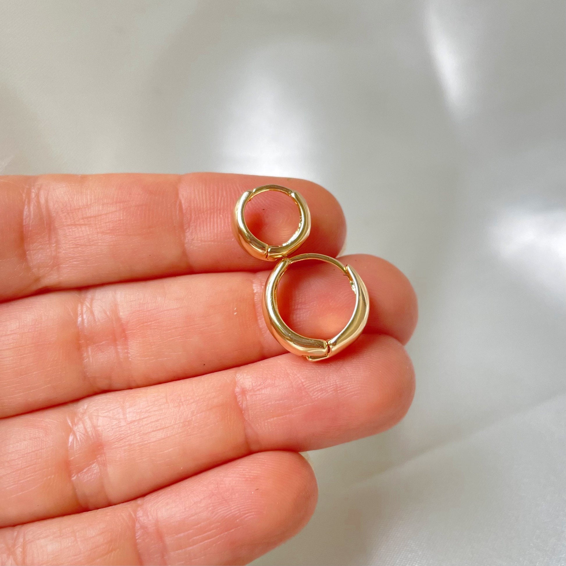 close up shot to medium thick gold filled chunky huggie hoop earrings