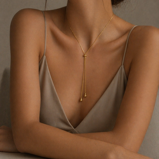 Woman wearing a gold stainless steel  necklace  adjustable against a neutral background