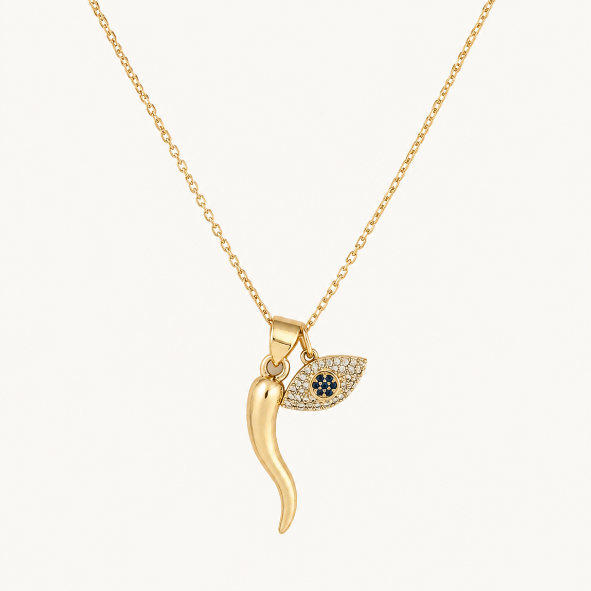 Gold filled  necklace with an italian  horn pendant and evil eye on a white background