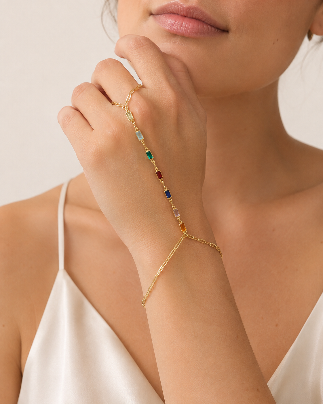 Multicolor hand chain bracelet in gold filled  on a wrist and hand wore by a woman