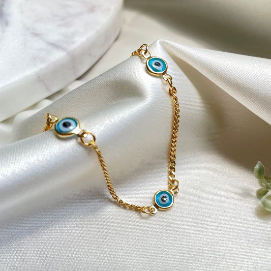 Light blue evil eye bracelet, 18k gold filled and white silk background