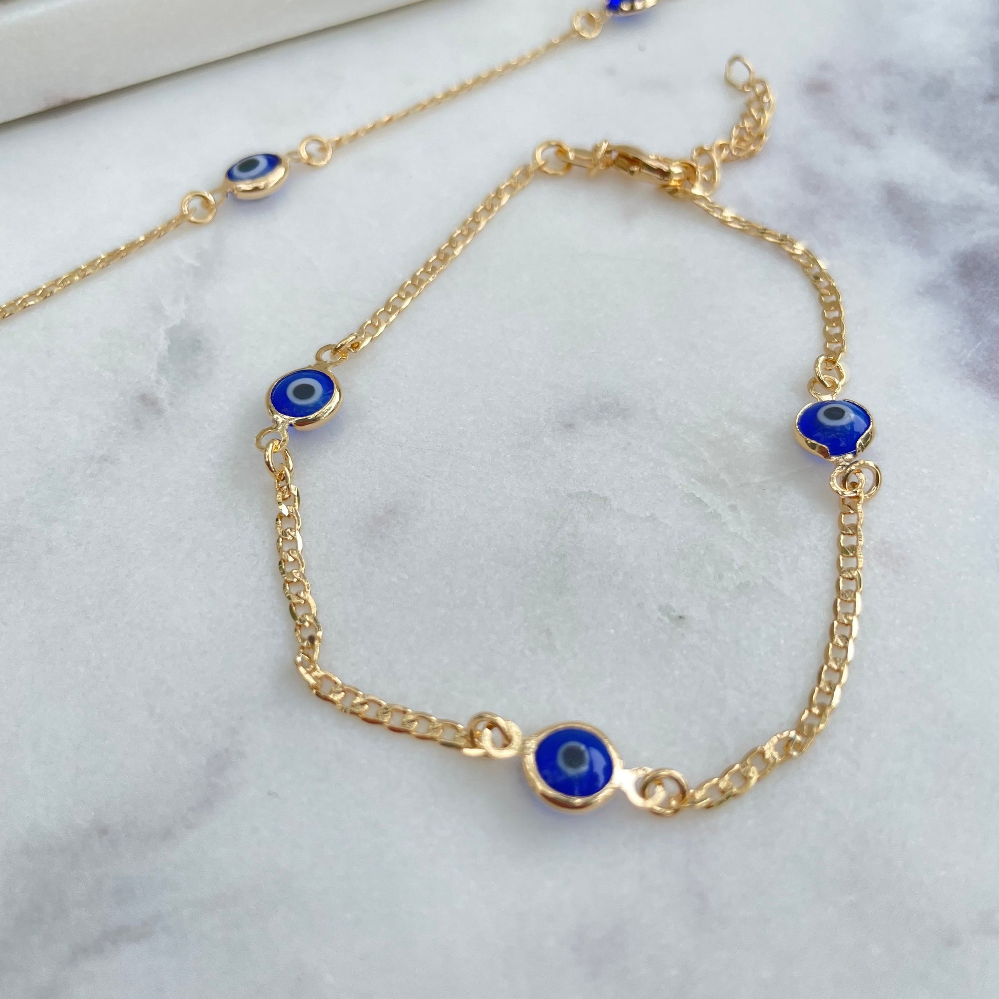 Royal blue evil eye bracelet, 18k gold filled and white silk background