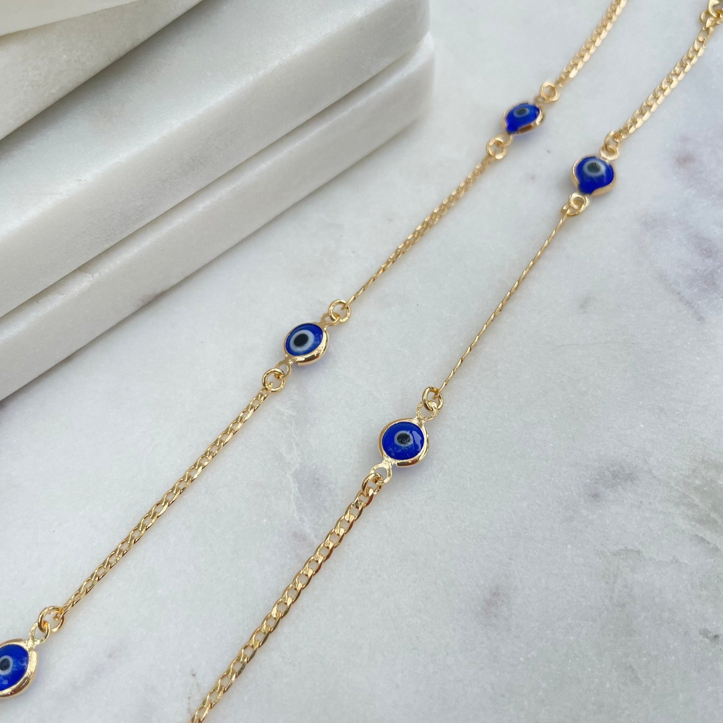 Royal blue evil eye bracelet, 18k gold filled, displayed on white marble tray.