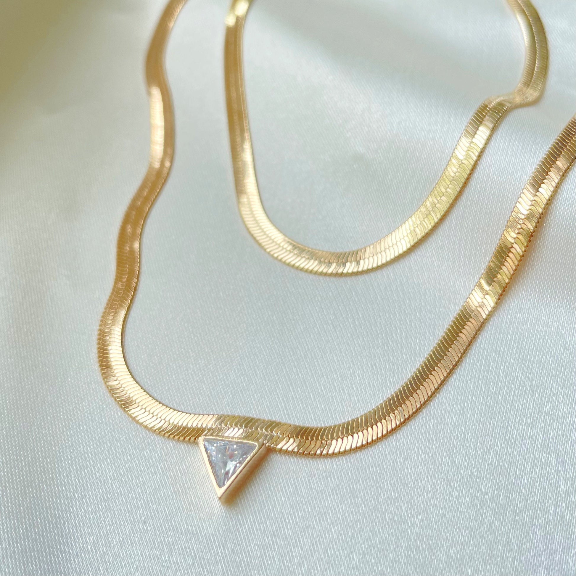 Two styles of herringbone choker necklace, one classic plain herringbone and the other with a cubic zirconia triangle in the middle. Doesn’t flip. Material 18k gold filled chain 