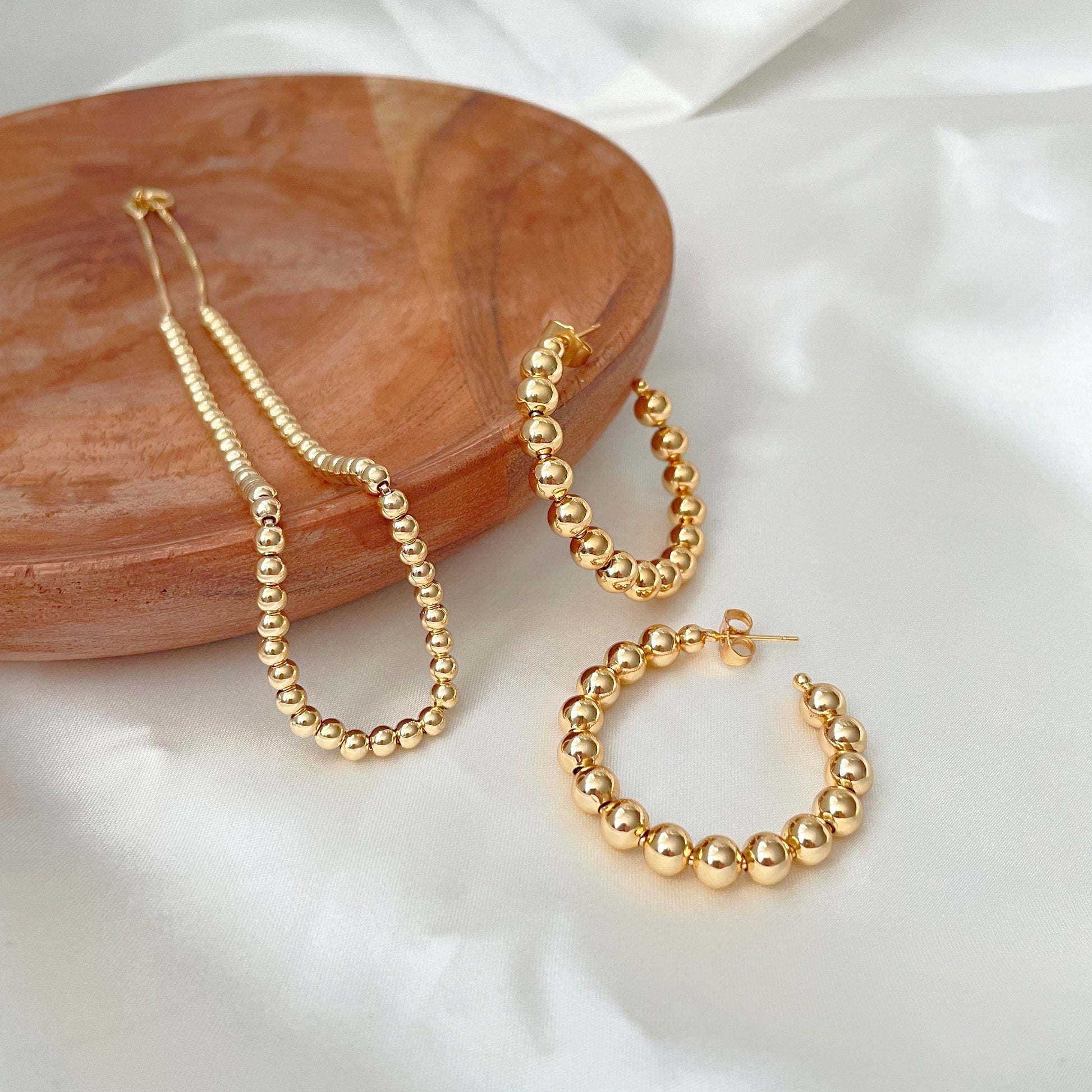 6 mm beaded hoop earrings in 18k gold filled displayed with 4 mm necklace also in 18k gold filled 