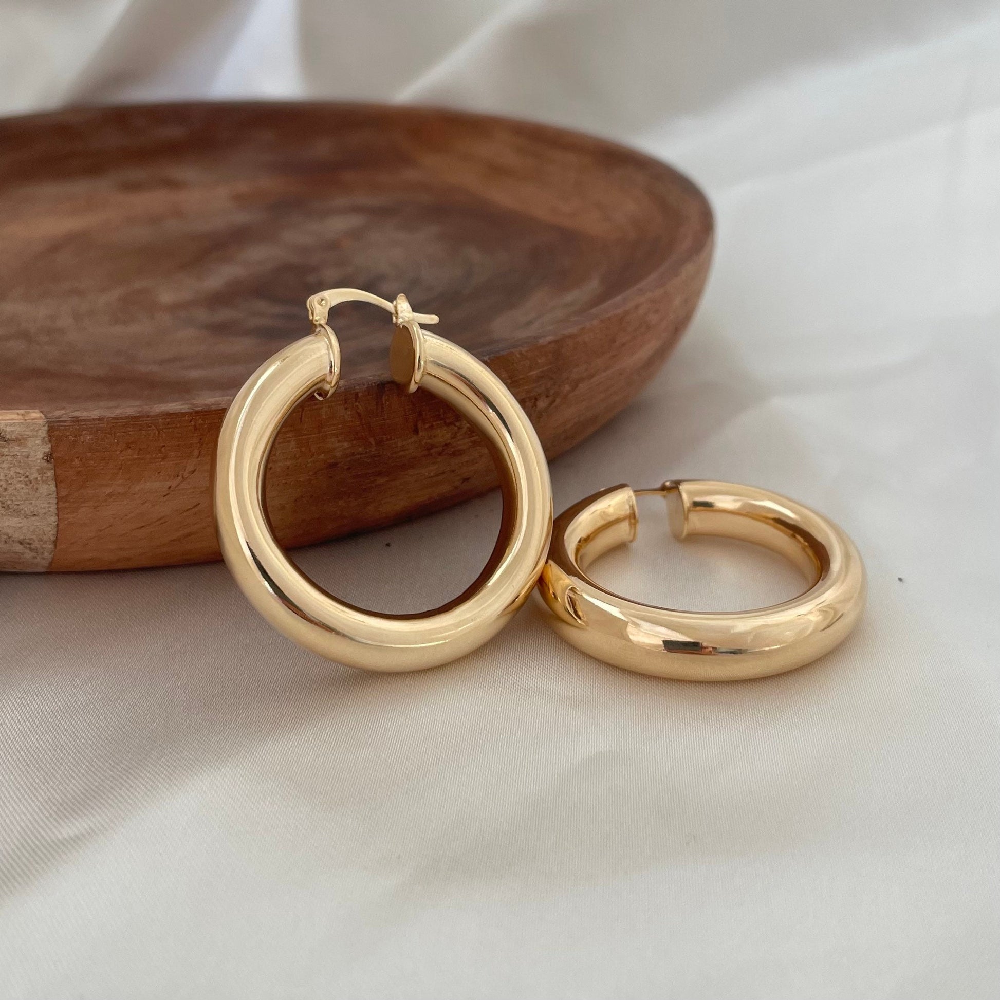 Chunky 18k gold filled hoop earrings, 6 mm thick and 1.7 inches diameter. Latch back closure. White silk background and wood tray as decor