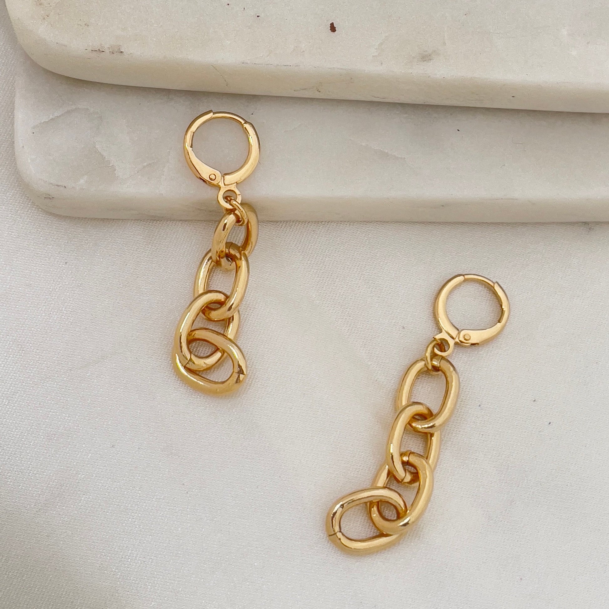 Chain hoop earrings made of 18k gold filled. White silk and marble background