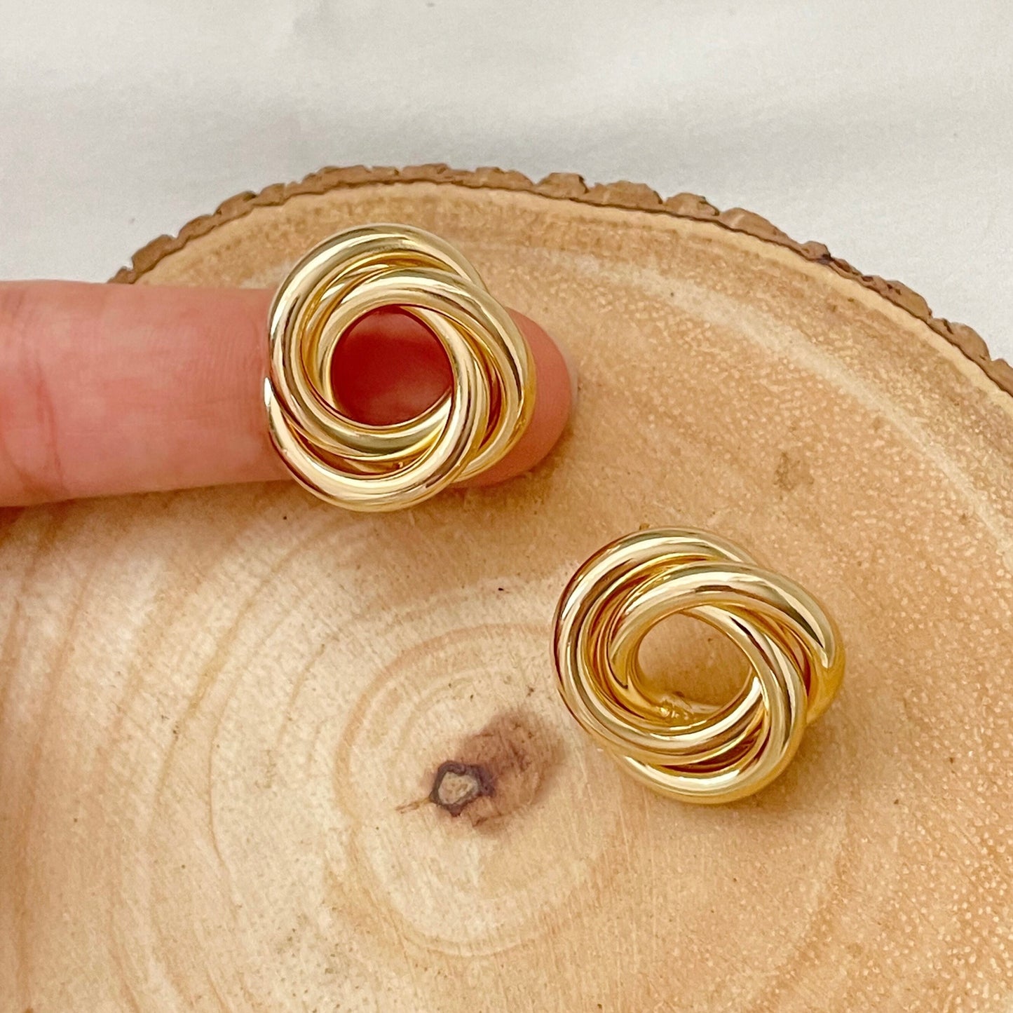 18k gold filled knot stud earrings, chunky and chubby knot earrings displayed on wood tray and white silk background 