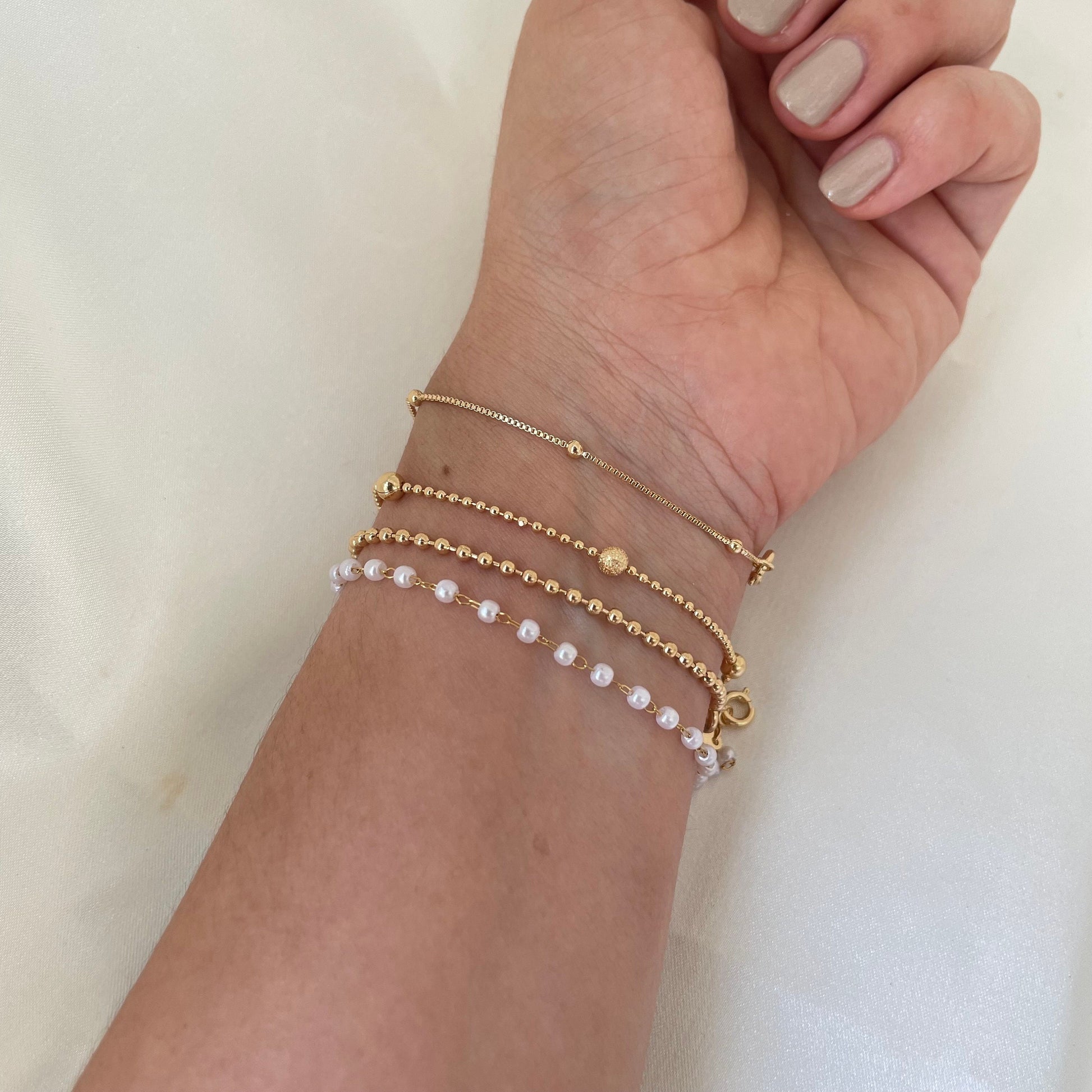 Bracelet stack of 4. 3mm faux pearl bracelet made of stainless steel, 2mm beaded chain made of 18k gold filled, 1mm and 4mm beaded bracelet in 18k gold filled and satellite chain bracelet. Sizes can be customize