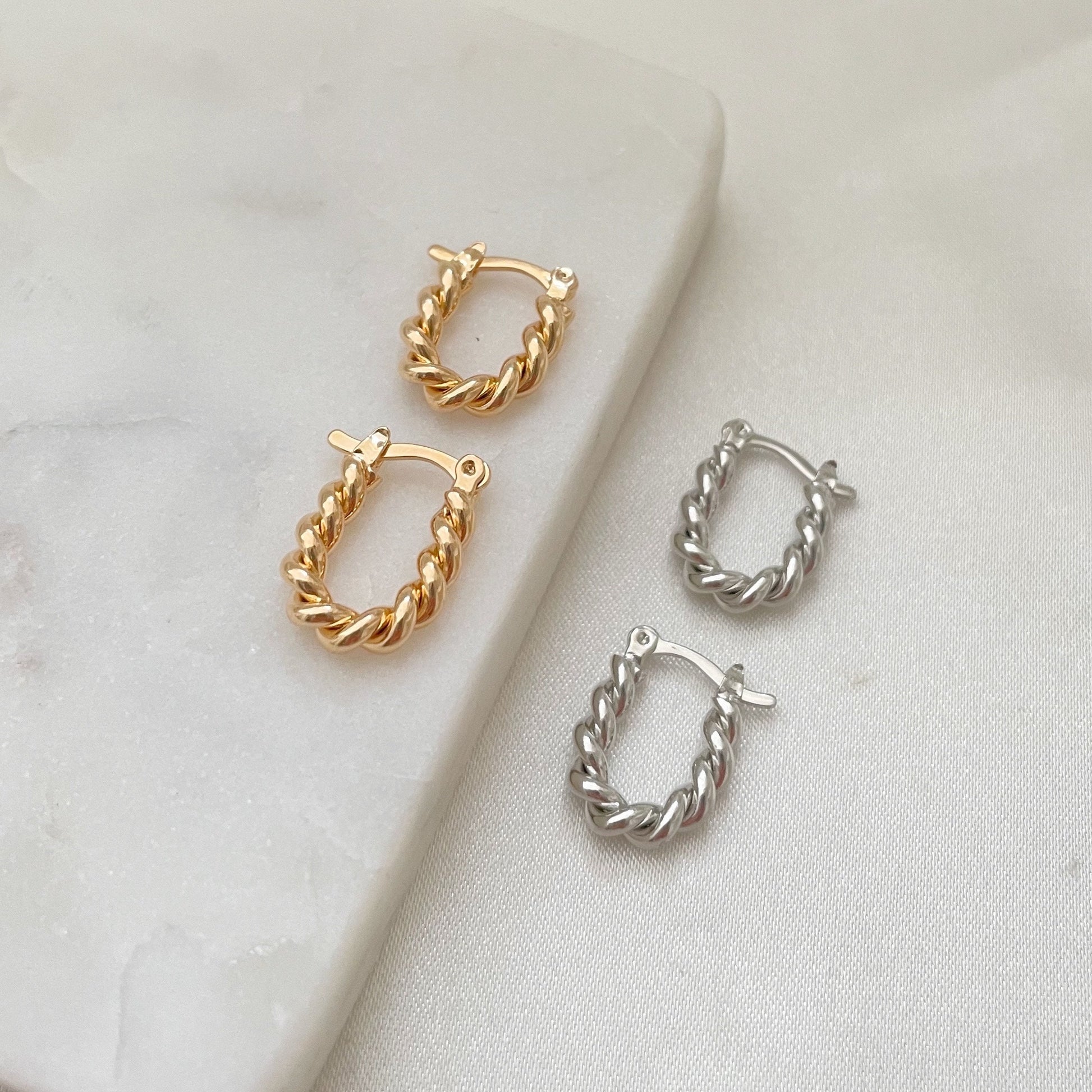 Set of 2 twisted square hoop earrings, made in 18k gold filled jewelry displayed on marble tray and white silk background