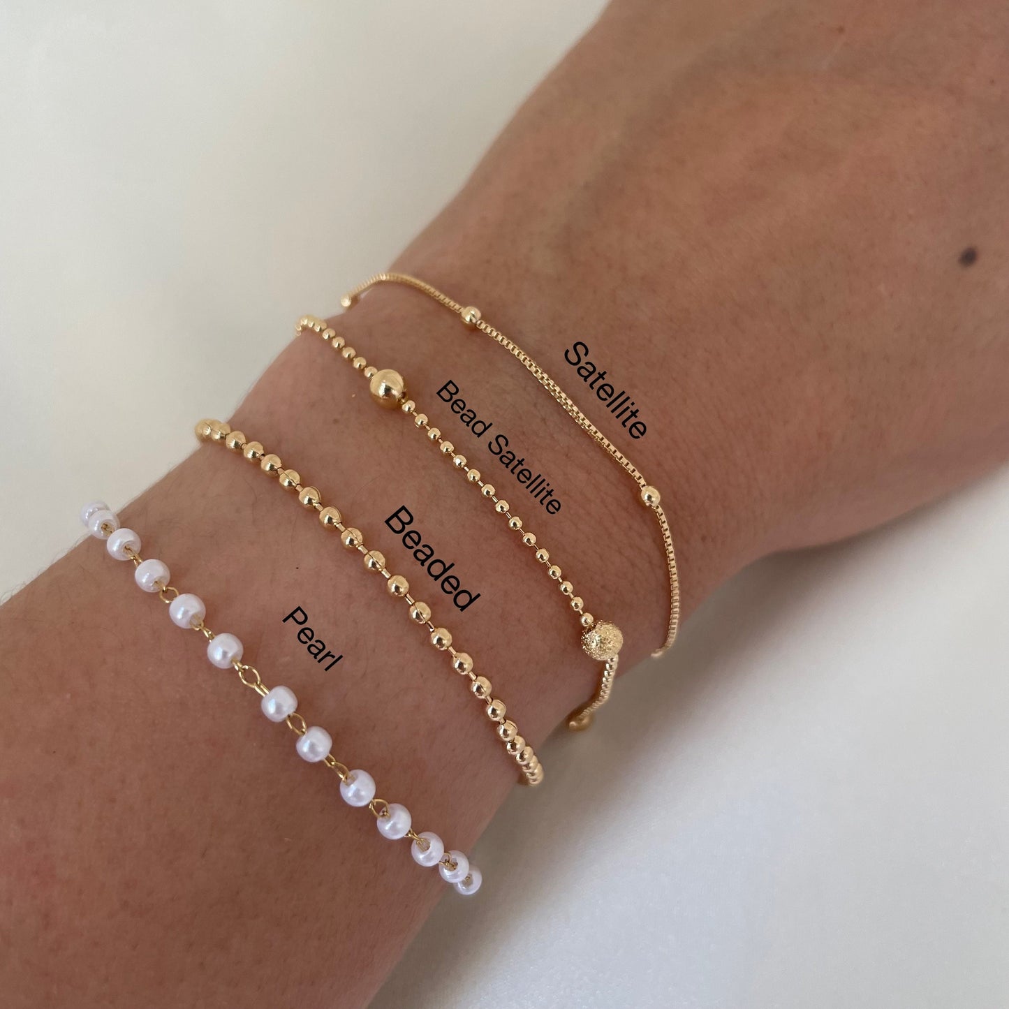 Bracelet stack of 4. 3mm faux pearl bracelet made of stainless steel, 2mm beaded chain made of 18k gold filled, 1mm and 4mm beaded bracelet in 18k gold filled and satellite chain bracelet. Sizes can be customize