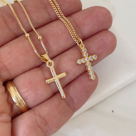 Cross Necklace, plain cross pendant and cz cross pendant. Materials: 18k gold filled and cz, shown in hand and white silk background