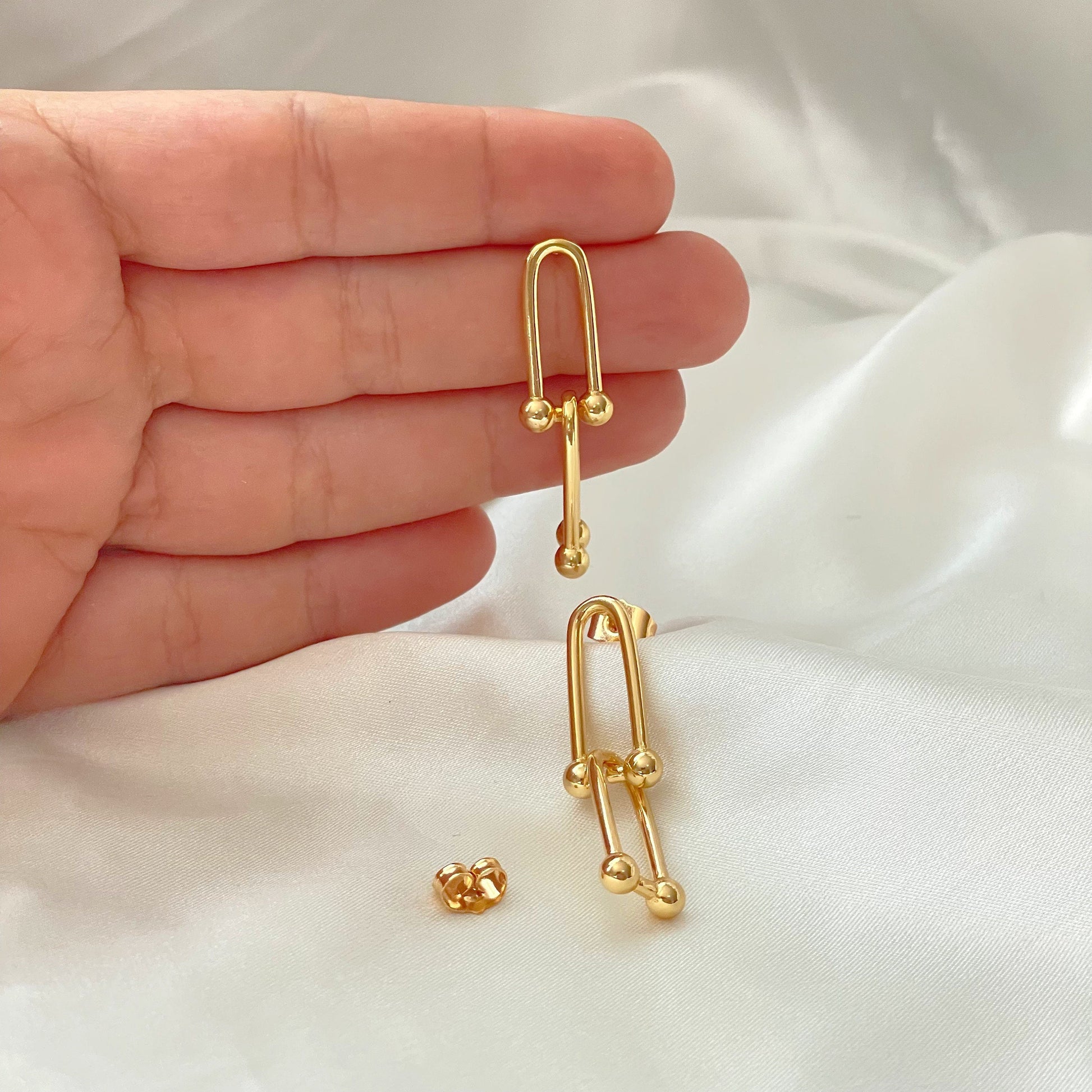 U link earrings in 18k gold filled displayed on hand